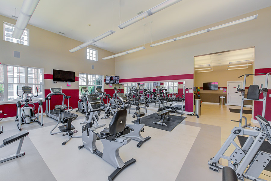 Fitness classes in exercise areas like this one at The Hamilton Luxury Apartment Homes are popular community events. Apartment fitness center with cardiovascular and strength training equipment